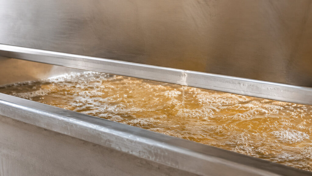Gewürztraminer juice showing mild natural browning as it collects in the press pan at Occasio Winery.