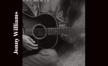 picture of jonny williams strumming an acoustic guitar