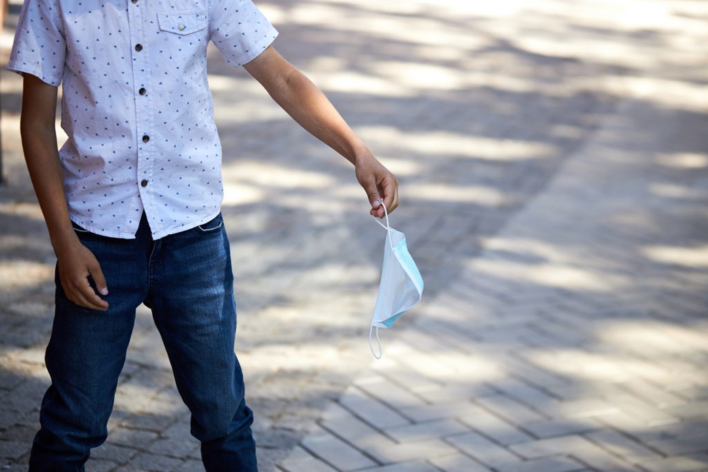 person throwing a mask away
