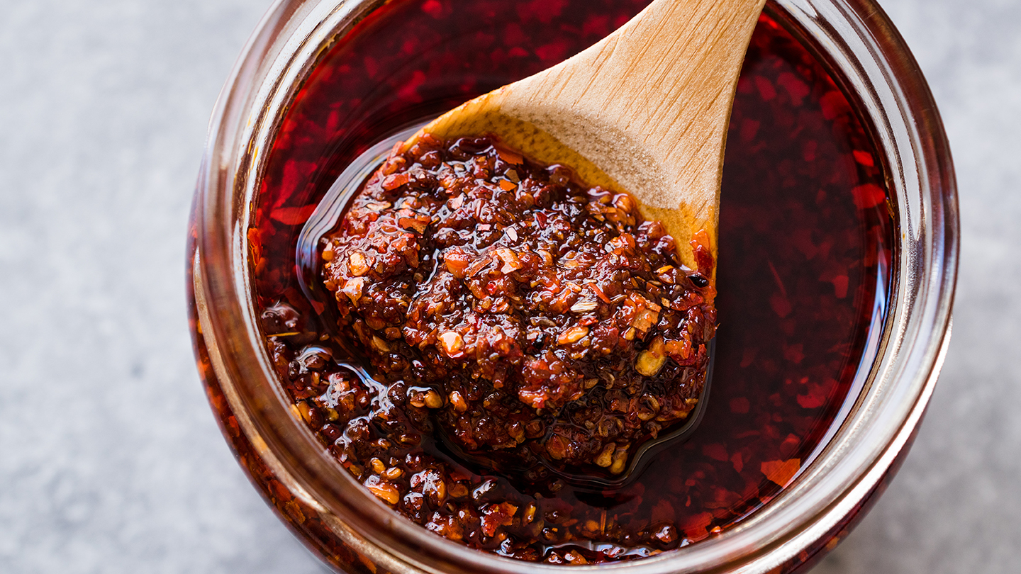 A JAR OF SALSA MACHA WITH A WOODEN SPOON IN IT